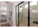 Modern bathroom featuring a glass shower with handrails and a walk-in closet nearby at 1631 N Lynch --, Mesa, AZ 85207