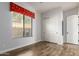 Bedroom with wood floors, window with red patterned valance, and closet at 1631 N Lynch --, Mesa, AZ 85207