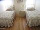 Cozy bedroom featuring two twin beds, wood-look floors, and soft, natural light from the windows at 1720 E Augusta Ave, Chandler, AZ 85249