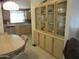 Features a china cabinet and a dining area with a round table and a partial view of the kitchen at 1720 E Augusta Ave, Chandler, AZ 85249