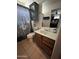 Cozy bathroom with a shower and vanity with a wood cabinet and sink, complemented by neutral tile flooring at 19045 N 45Th Ave, Glendale, AZ 85308