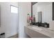 Elegant powder room with stone countertop, black fixtures, and a stylish orchid at 1920 E Creek Canyon Rd, Phoenix, AZ 85086