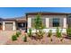Charming single-story home with a well-manicured front yard, stone accents, and a matching detached garage at 23769 N 163Rd Dr, Surprise, AZ 85387
