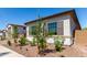 Charming front yard with desert landscaping, young trees, and exterior shutters at 23769 N 163Rd Dr, Surprise, AZ 85387