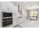 Modern kitchen featuring stainless steel appliances, white cabinets, and a sleek backsplash design at 23769 N 163Rd Dr, Surprise, AZ 85387