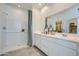 Bright bathroom featuring double sinks, shower and large mirror reflecting a walk-in closet at 24886 N 167Th Dr, Surprise, AZ 85387