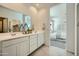 Elegant bathroom featuring double sinks, white cabinets, and a large mirror reflecting the bedroom at 24886 N 167Th Dr, Surprise, AZ 85387