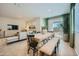 Elegant dining area with a large wooden table, bench seating, and natural light from a sliding glass door at 24886 N 167Th Dr, Surprise, AZ 85387