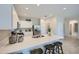 Bright kitchen featuring white cabinets, stainless steel appliances, and a breakfast bar with wooden barstools at 24886 N 167Th Dr, Surprise, AZ 85387