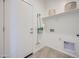 Clean laundry room with white walls, shelving, and convenient access door at 24886 N 167Th Dr, Surprise, AZ 85387