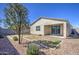 Spacious backyard featuring desert landscaping, a covered patio, and a well-maintained stucco home at 36217 N Urika Dr, San Tan Valley, AZ 85140