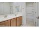 Clean bathroom with a double sink vanity, framed mirror and separate door into the bath and shower at 36217 N Urika Dr, San Tan Valley, AZ 85140