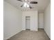 Bright bedroom featuring a ceiling fan, a closet with sliding doors, and an ensuite door at 36217 N Urika Dr, San Tan Valley, AZ 85140