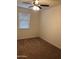 An empty bedroom with neutral walls and carpet, ceiling fan, and a window with blinds at 36217 N Urika Dr, San Tan Valley, AZ 85140