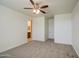 Spacious bedroom featuring neutral carpet, ceiling fan, and easy access to the bathroom at 36217 N Urika Dr, San Tan Valley, AZ 85140