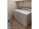 Bright laundry room featuring a modern, white washer and dryer set and tiled floor at 36217 N Urika Dr, San Tan Valley, AZ 85140