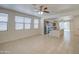 Bright living space with neutral tile flooring, ceiling fan, and abundant natural light from large windows at 36217 N Urika Dr, San Tan Valley, AZ 85140