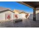 Covered patio and backyard featuring a gas firepit, brick privacy wall, and decorative vines at 4156 E Bernice St, Gilbert, AZ 85295