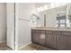 Bathroom featuring double sinks with dark cabinets, a large mirror, and modern lighting fixtures at 4156 E Bernice St, Gilbert, AZ 85295