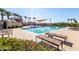 Large community pool area featuring lounge chairs, shade structures, palm trees, and well-maintained landscaping at 4156 E Bernice St, Gilbert, AZ 85295