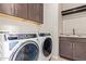 Well-equipped laundry room with modern washer, dryer, sink, and overhead cabinets at 4156 E Bernice St, Gilbert, AZ 85295