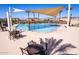 Outdoor community pool with lounge seating and sunshades with the neighborhood in the background at 4156 E Bernice St, Gilbert, AZ 85295