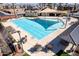 Overhead view of a community pool with lounge chairs, tables, and sun shades surrounded by green landscaping at 4156 E Bernice St, Gilbert, AZ 85295