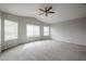 Large bedroom with multiple windows that provide natural light, ceiling fan, and neutral carpet at 4613 E Douglas Ave, Gilbert, AZ 85234