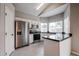 Well-lit kitchen with stainless steel appliances, black countertops, and a breakfast bar at 4613 E Douglas Ave, Gilbert, AZ 85234