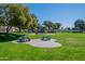 This park offers a playground and picnic tables and is surrounded by lush green grass and mature trees at 4613 E Douglas Ave, Gilbert, AZ 85234