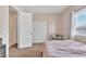 A sunlit bedroom featuring carpet floors, a window with curtains, and access to other rooms at 6409 S 49Th Dr, Laveen, AZ 85339