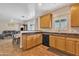 A kitchen with a breakfast bar open to the dining and living area, featuring light wood cabinets at 6409 S 49Th Dr, Laveen, AZ 85339