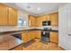 Well-equipped kitchen featuring wood cabinets, black appliances, and laminate countertops at 6409 S 49Th Dr, Laveen, AZ 85339