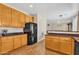 An open kitchen featuring wood-style flooring, light wood cabinets, and dark countertops at 6409 S 49Th Dr, Laveen, AZ 85339