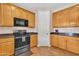 A well-lit kitchen with modern appliances, wood-style flooring, and light wood cabinets at 6409 S 49Th Dr, Laveen, AZ 85339