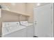 A laundry room with a side-by-side washer and dryer and wire shelving above at 6409 S 49Th Dr, Laveen, AZ 85339