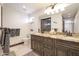 Stylish bathroom boasts a double vanity with granite counters and dark wood cabinets and framed mirror at 7481 E Camino Santo --, Scottsdale, AZ 85260