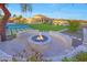 Inviting backyard fire pit with seating, lush lawn, and a tennis court for entertainment at 7481 E Camino Santo --, Scottsdale, AZ 85260