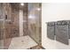 Elegant walk-in shower with marble tiling, pebble flooring, and glass enclosure at 7481 E Camino Santo --, Scottsdale, AZ 85260