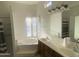 Bright bathroom with double sinks, soaking tub, and natural light from the glass block window at 7636 E Coronado Rd, Mesa, AZ 85207