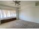 Spacious bedroom with neutral carpet, a ceiling fan, and a window bench for extra seating and storage at 7636 E Coronado Rd, Mesa, AZ 85207