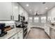 Modern kitchen with white cabinets, granite countertops, stainless steel appliances, and wood-look floors at 8576 W Mclellan Rd, Glendale, AZ 85305