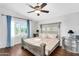 Serene main bedroom with hardwood floors, decorative ceiling fan, and a sunlit window at 8781 S Mill Ave, Tempe, AZ 85284