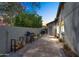 Side yard with paved walkway, gas grill, wood storage against stucco wall at 8781 S Mill Ave, Tempe, AZ 85284