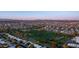 A birds eye view of a suburban neighborhood next to a golf course as the sun sets on the horizon at 9523 W Sandstone Dr, Sun City, AZ 85351