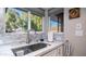 Bright kitchen sink area with marble backsplash, modern faucet, and a sunny window view at 9523 W Sandstone Dr, Sun City, AZ 85351