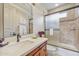 Bright bathroom featuring a vanity with ample counter space, a shower with glass doors, and neutral-toned tiles at 10040 E Happy Valley Rd # 269, Scottsdale, AZ 85255
