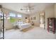 Bright bedroom with neutral tones, featuring a comfortable bed, ceiling fan, and scenic views from the windows at 10040 E Happy Valley Rd # 269, Scottsdale, AZ 85255