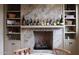Cozy fireplace with decorative tile, custom built-ins, and displayed wine bottles at 10040 E Happy Valley Rd # 269, Scottsdale, AZ 85255