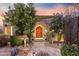 Elegant front entrance with stone archway, a carved wooden door, desert landscaping, and a stone paver walkway at 10040 E Happy Valley Rd # 269, Scottsdale, AZ 85255